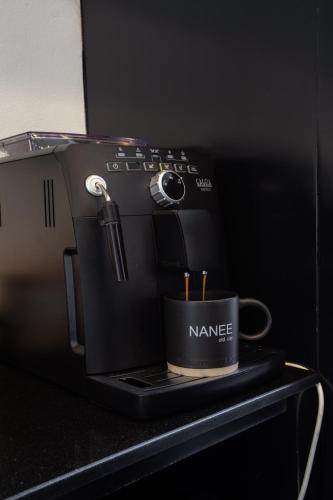 a coffee maker with a cup on a counter at NANEE Phra Singh in Chiang Mai