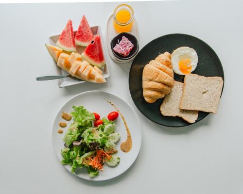 a table with two plates of food with bread and a salad at NANEE Phra Singh in Chiang Mai