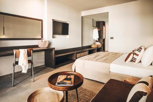 a hotel room with a bed and a table at Cook's Club Ialysos Rhodes in Ialyssos