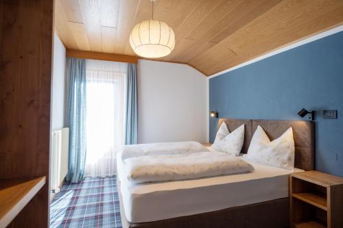 a bedroom with a large white bed with a blue wall at Chalet Fisti in La Villa