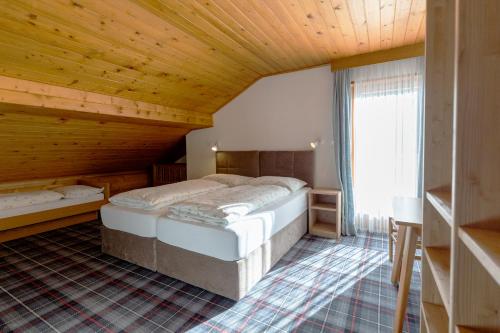 a bedroom with two beds in a room with wooden ceilings at Chalet Fisti in La Villa