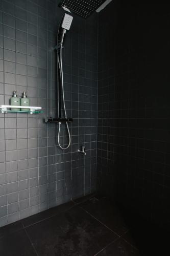 a bathroom with a shower in a dark room at NANEE Phra Singh in Chiang Mai