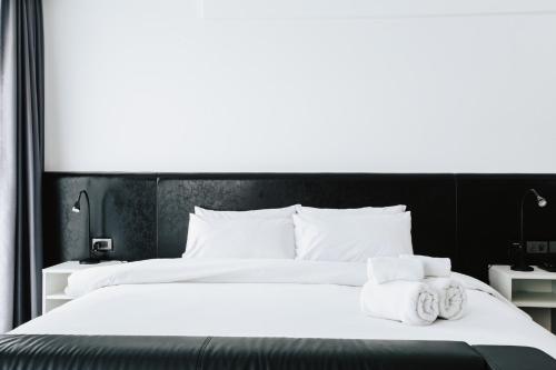 a bedroom with a large white bed with towels on it at NANEE Phra Singh in Chiang Mai