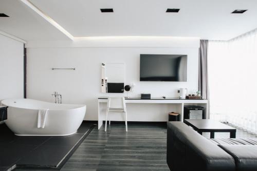 a bathroom with a tub and a tv on the wall at NANEE Phra Singh in Chiang Mai