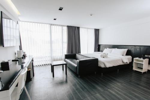 a hotel room with a bed and a couch at NANEE Phra Singh in Chiang Mai