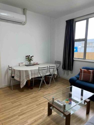 a living room with a table and chairs and a window at Sunny apartment in central Karori in Wellington