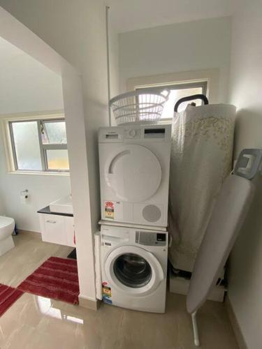 a laundry room with a washing machine in it at Sunny apartment in central Karori in Wellington