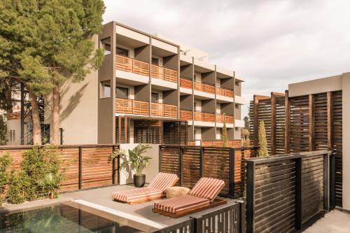 an apartment building with a patio and a swimming pool at Cook's Club Ialysos Rhodes in Ialyssos