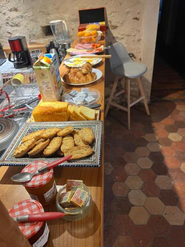 a buffet line with various types of bread and pastries at Le domaine de Brie in Châtillon-la-Borde