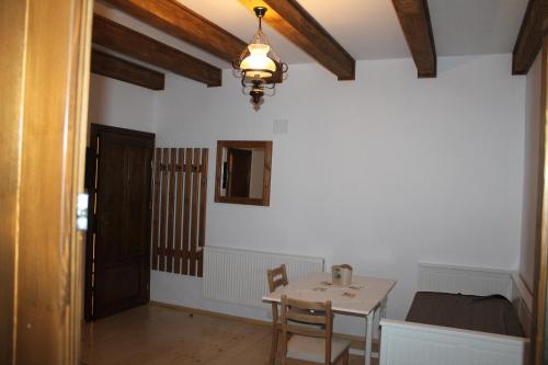 a dining room with a table and a room with a bed at Arnica Montana in Arieşeni