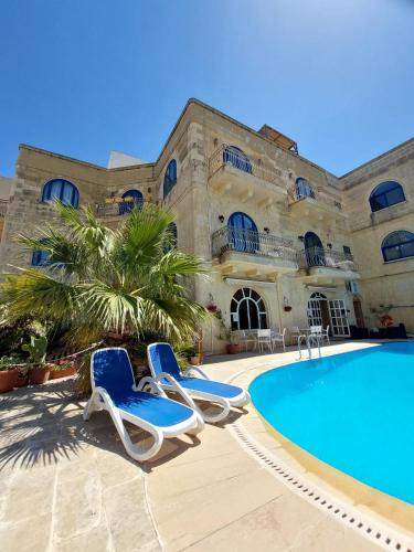 a resort with two chairs and a swimming pool at Villa Serenity B&B in Sannat