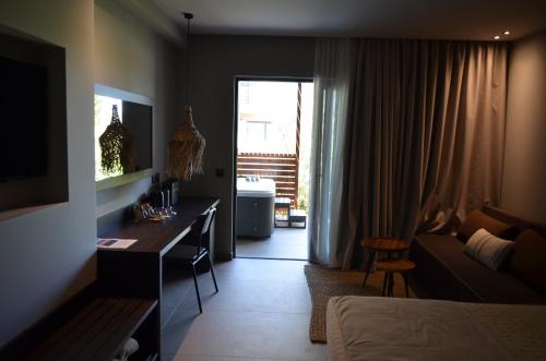 a hotel room with a desk and a bedroom at Cook's Club Ialysos Rhodes in Ialyssos
