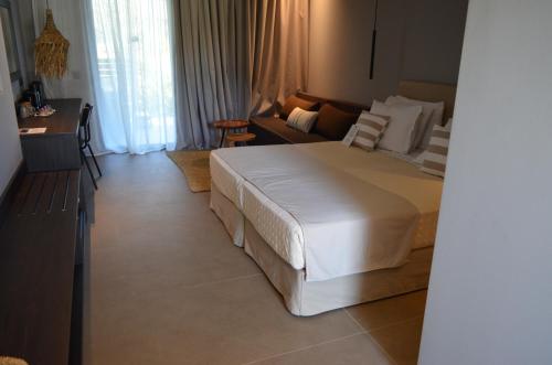 a bedroom with a large white bed and a couch at Cook's Club Ialysos Rhodes in Ialyssos