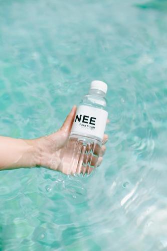 a person holding a bottle of water in the water at NANEE Phra Singh in Chiang Mai