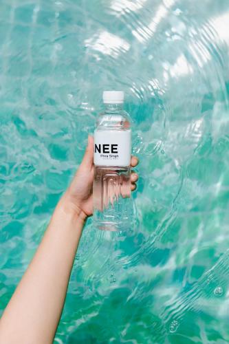 a person holding a bottle of water in the swimming pool at NANEE Phra Singh in Chiang Mai