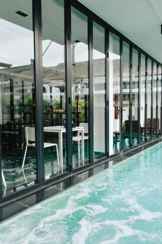 a swimming pool with a table and chairs on a building at NANEE Phra Singh in Chiang Mai