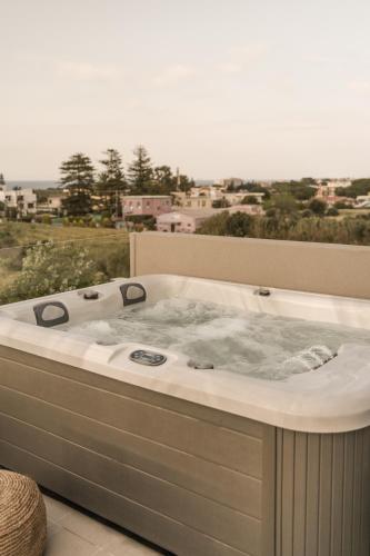 a jacuzzi tub on a balcony with a view at Cook's Club Ialysos Rhodes in Ialyssos