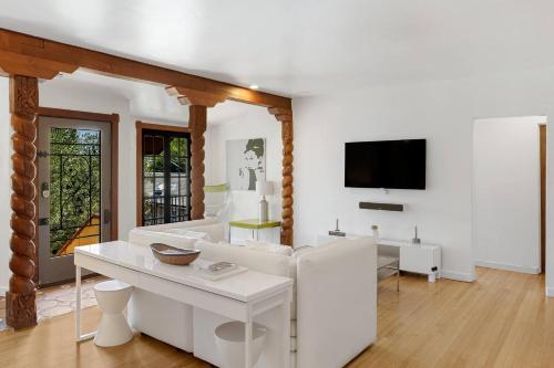 a white living room with a white couch and a tv at Hollywood Hills Walk to Universal City Views in Los Angeles