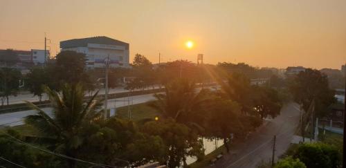 a sunset over a city with palm trees and a street at P Bliss hotel in Phayao