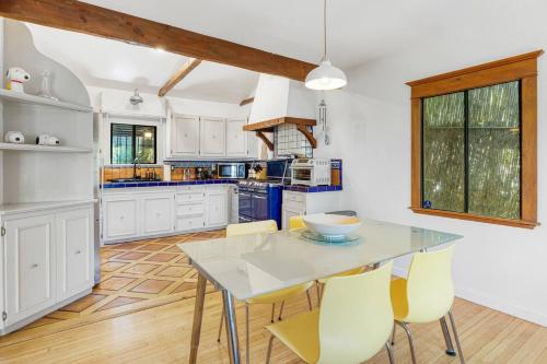 a kitchen with a glass table and yellow chairs at Hollywood Hills Walk to Universal City Views in Los Angeles