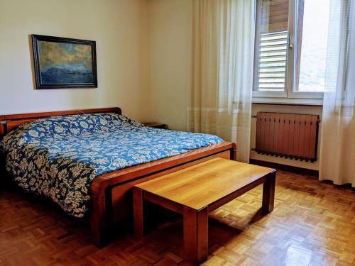 a bedroom with a bed and a wooden table at Lakeview apartment in Pergine Valsugana