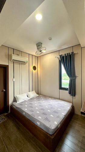 a large bed in a room with a window at Mộc Trà Hotel in Ho Chi Minh City
