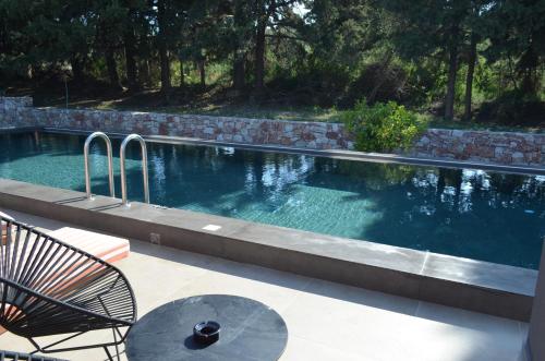 a swimming pool with a table and chairs next to it at Cook's Club Ialysos Rhodes in Ialyssos