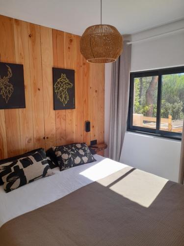 - une chambre avec un lit et un mur en bois dans l'établissement Gîte en Provence pour amoureux de la nature, à Rognes