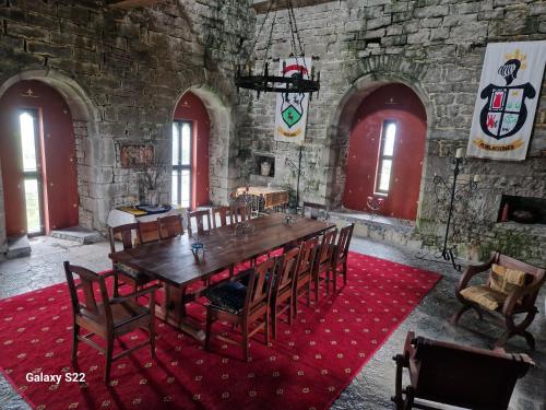 a dining room with a large wooden table and chairs at Ballindooley Castle in Galway
