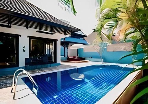 a swimming pool in front of a house at Ramada by Wyndham Aonang Krabi in Ao Nang Beach