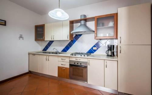 a kitchen with white cabinets and a stove top oven at Villa Righino in Murlo