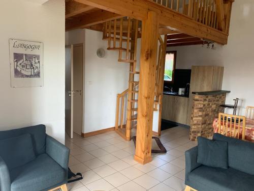 - un salon avec deux chaises bleues et un escalier dans l'établissement Lac de Naussac, à Langogne