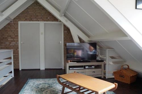 a living room with a tv and a table at Natuurhuis Drents-Friese Wold in Zorgvlied