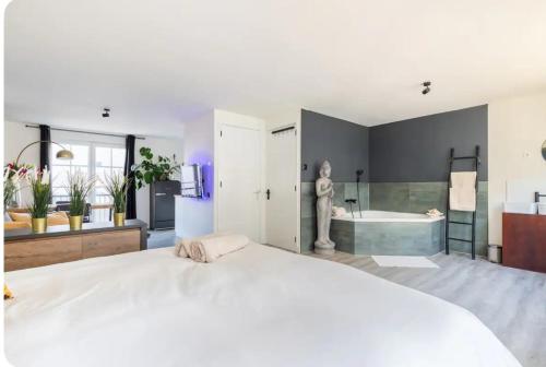 a large bedroom with a large bed and a bath tub at Studio Romantic in Zandvoort