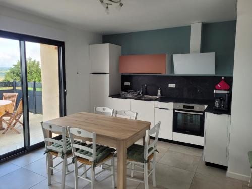 a kitchen with a wooden table and chairs at Vielle grange rénovéeTout confort in Comps-la-Grand-Ville