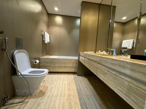 a bathroom with a toilet and a sink and a tub at DAMAC Towers Riyadh by SELSAL داماك الرياض in Riyadh