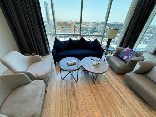 a living room with a couch and chairs and a table at DAMAC Towers Riyadh by SELSAL داماك الرياض in Riyadh