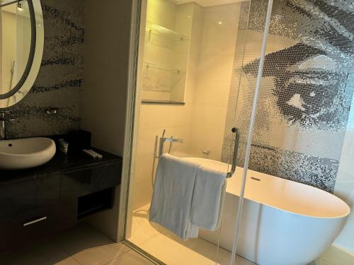 a bathroom with a bath tub and a sink at DAMAC Towers Riyadh by SELSAL داماك الرياض in Riyadh