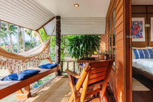 Pokój z hamakiem, łóżkiem i balkonem w obiekcie Cottage Hin Kong w mieście Hinkong