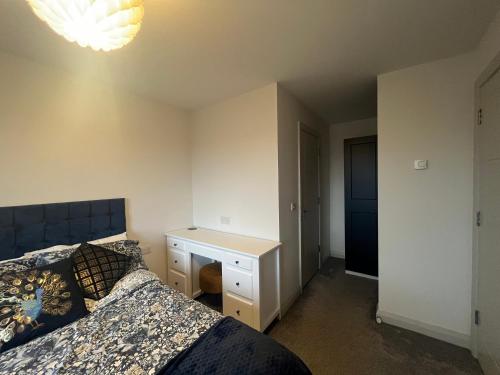 a bedroom with a bed and a night stand with a desk at Nine Hatherans in Portstewart