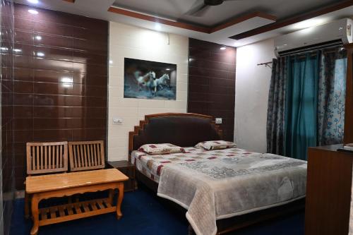 a small bedroom with a bed and a table at Hotel Sunrise in Chandīgarh
