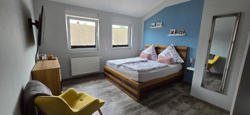 a small bedroom with a bed and a chair at Mein Quartier am Harz in Herzberg am Harz