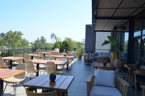 a restaurant with tables and chairs on a balcony at Cook's Club Ialysos Rhodes in Ialyssos