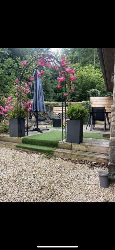 un parc avec une aire de jeux aux fleurs roses et une balançoire dans l'établissement Studio d’étape, robinson Plaintel, à Plaintel