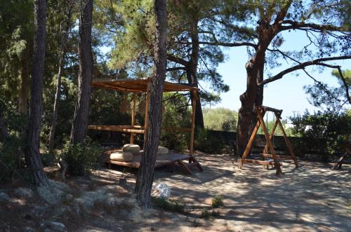 a swing set in a park with trees at Cook's Club Ialysos Rhodes in Ialyssos