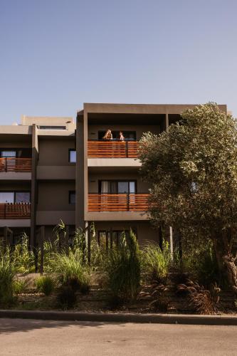 two people sitting on a balcony of a building at Cook's Club Ialysos Rhodes in Ialyssos