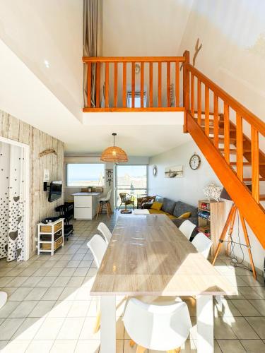 une salle à manger et un salon avec une grande table en bois dans l'établissement JACUZZI professionel Les pieds dans l'eau plage à 50 m, à Trévou-Tréguignec