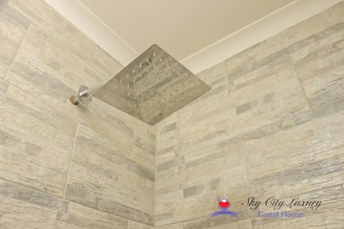 a bathroom with a tile floor and a ceiling at Sky city luxury guest house in Alberton