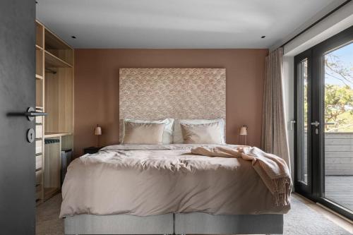 a bedroom with a large bed with a large window at Idyllisk sted på toppen av Alshus , Kråkerøy in Kråkerøy