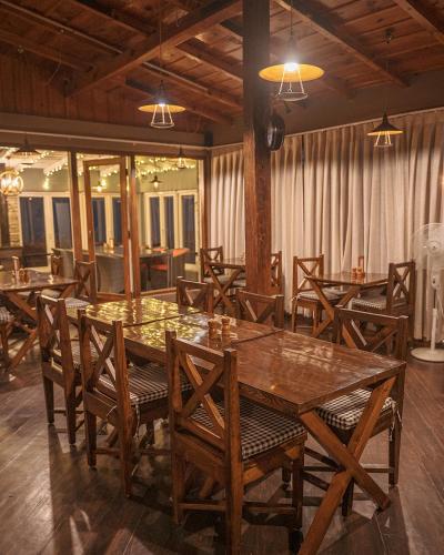 a dining room with wooden tables and chairs at The Birdcage, Mukteshwar in Mukteshwar